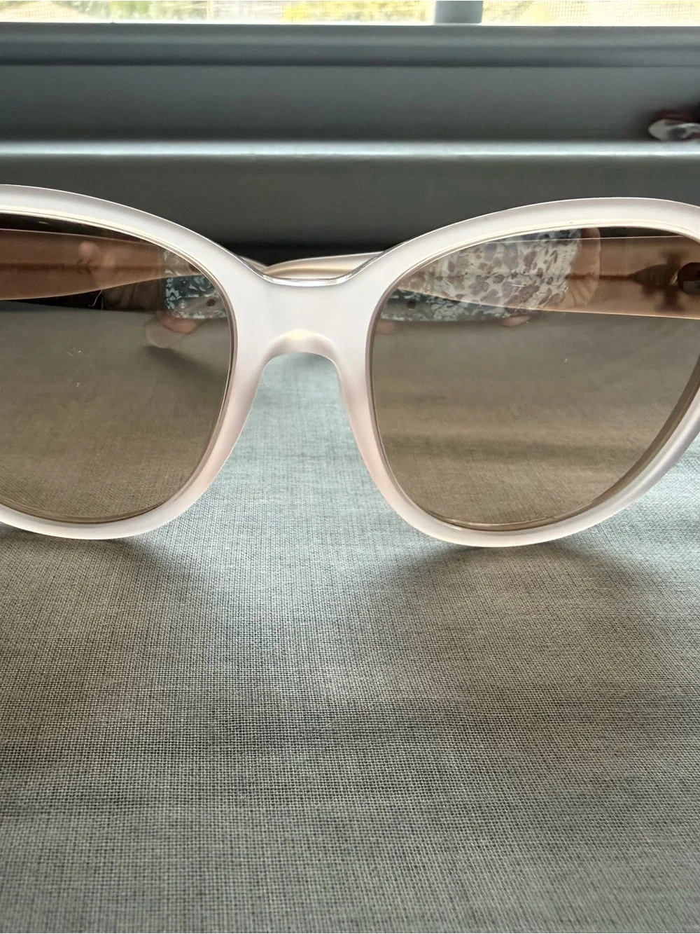 Tory Burch Pale Pink Frame Sunglasses with cat eye shape with gold detail.